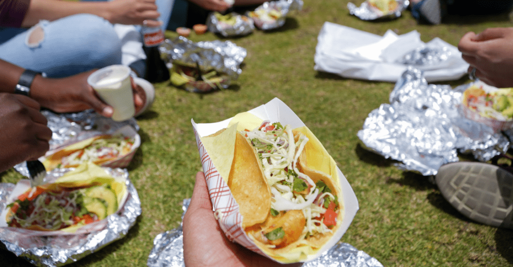 Group of friends enjoying tacos in the park in San Diego