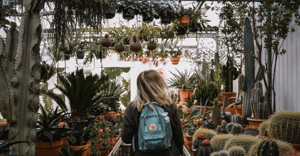 woman walking through a plant nursery 